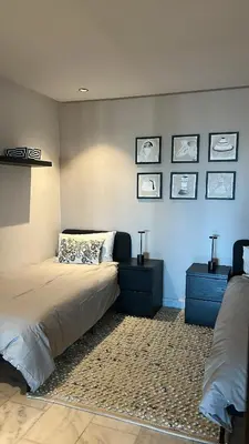a bedroom with a bed with two night stands and two tables at Le Balcon du Port in Casablanca