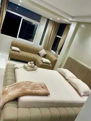 a large bed and couch in a room with windows at L oasis cachée à deux pas de plage et piscine in Mohammedia