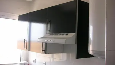 a kitchen with black cabinets and a white stove top oven at Bouznika H18 in Bouznika
