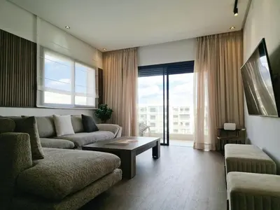 a living room with a couch and a table at Neo Home in Bouznika