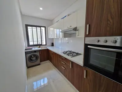 a kitchen with a stove and a washer and dryer at Neo Home in Bouznika