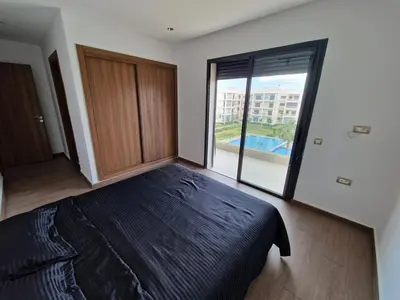 a bedroom with a large bed and a large window at Neo Home in Bouznika