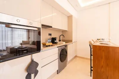 a kitchen with white cabinets and a living room at Les Princesses studio, self check-in, parking in Casablanca