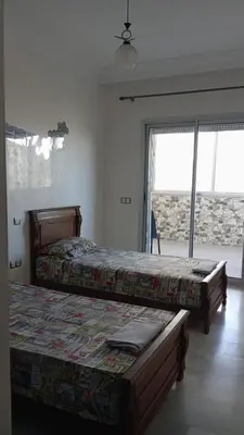 a bedroom with two beds and a large window at La Siesta Beach Resort in Mohammedia