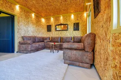 a living room with a leather couch and a table at Grande villa luxueuse face à l'Océan in Temara