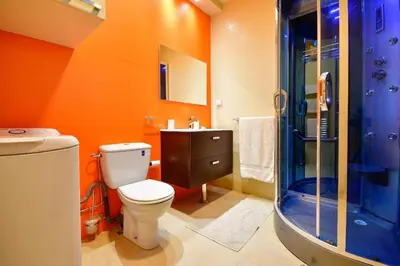 an orange bathroom with a toilet and a shower at Grande villa luxueuse face à l'Océan in Temara