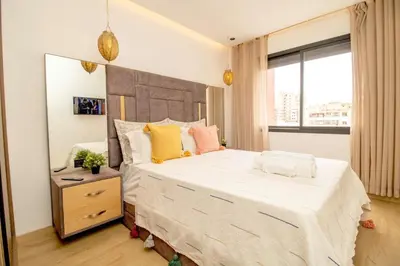a bedroom with a large white bed with yellow and pink pillows at AS29 studio luxueux au centre casablanca Tramway Parking free in Casablanca