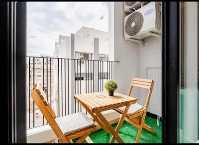 a balcony with a wooden table and two chairs at AS29 studio luxueux au centre casablanca Tramway Parking free in Casablanca
