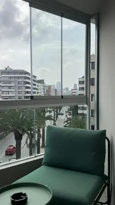 a green couch sitting in front of a large window at The CFC View - By AppartAli in Casablanca