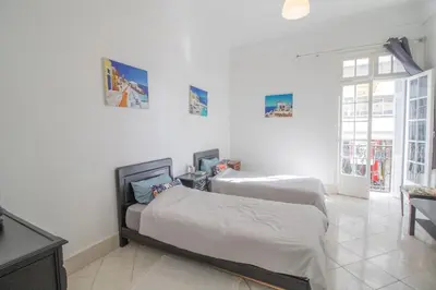 two beds in a room with white walls at Spacious Family Apartment in Casablanca in Casablanca