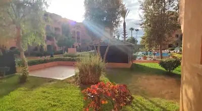 a rainbow over a garden with a building and flowers at Ricoflores Mansouria in Mansouria