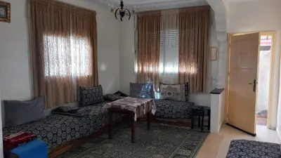 a living room with a couch and a table at Maison équipée prêt de la plage in Temara