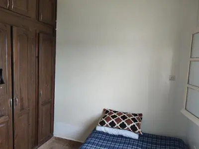 a pillow sitting on a bed in a room at Maison équipée prêt de la plage in Temara