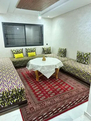 a living room with a table and some couches at Appartement à Témara - Élégance et confort in Temara