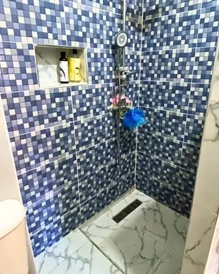 a bathroom with a shower with blue and white tiles at Appartement Calme à Mohammadia - Séjour Agréable in Mohammedia