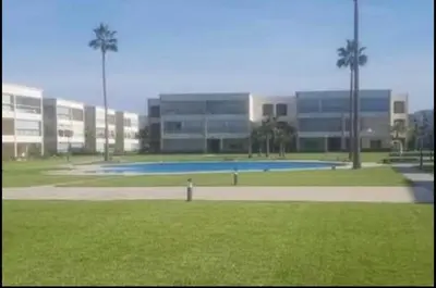 a building with a pool in the middle of a park at appartement ola blanca 2 in Dar Hamida