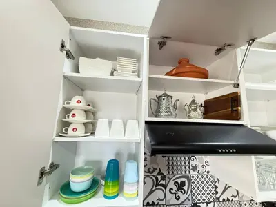 a kitchen pantry with white shelves and dishes at La Casa in Tamaris