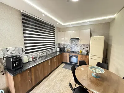 a kitchen with a wooden table and a table and a refrigerator at La Casa in Tamaris