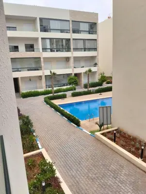 a swimming pool in front of a building at Appartement avec piscine El mansoria Mohammedia in Mansouria