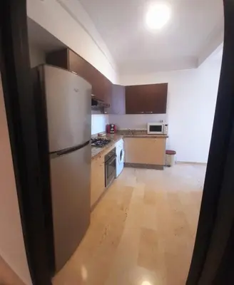 a kitchen with a stainless steel refrigerator and wooden cabinets at Appartamento Narjis in Casablanca