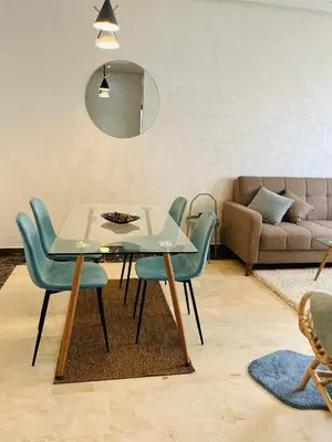 a table and chairs in a living room with a couch at Elegant & Cozy Beach Apartment in Mohammedia