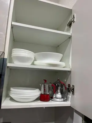 a cupboard with plates and dishes and a mixer at Elegant & Cozy Beach Apartment in Mohammedia