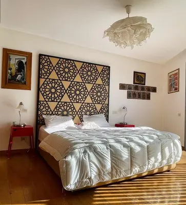 a bedroom with a large bed with a large headboard at Élégance et Vue sur l'Océan in Casablanca