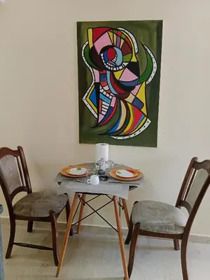 a table with two chairs and a painting on the wall at Résidence journalière chic Casablanca in Casablanca