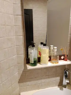 a bathroom sink with bottles on a shelf next to a mirror at La maison de rêve in Casablanca