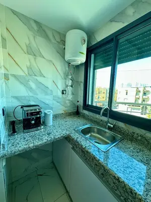 a kitchen counter with a sink and a window at Appartement haut standing, 2 chambres - Mohammedia in Mohammedia
