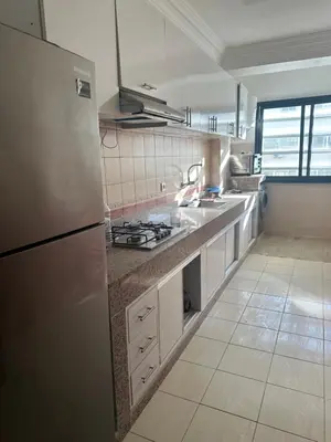 a kitchen with a stainless steel refrigerator and a tile floor at appartement a 1 min de la plage in Casablanca