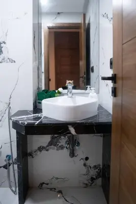 a bathroom with a white sink and a mirror at Appart familial cœur Casa in Casablanca