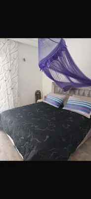 a bedroom with a bed with a purple canopy at Marbella Beach apartement holiday 2 chambres,piscine et plage in Mansouria