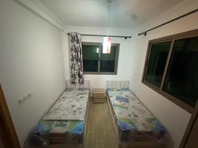 a small room with two beds and a window at Yasmine Beach in Mansouria