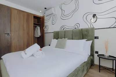 a bedroom with two white beds and a wall with drawings on it at The Shelter Residence by GoodMove - Bourgogne, Casablanca in Casablanca