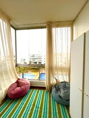 a room with a large window and two bean bags at Seaside appartment with private pool in Tamaris