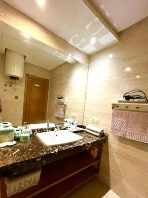 a bathroom with a sink and a large mirror at Seaside appartment with private pool in Tamaris