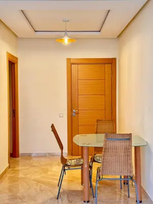 a dining room with a table and two chairs at Bright Apt with Balcony, WiFi, Parking and Pool Resort in Bouznika