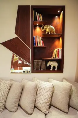 a book shelf above a couch with pillows at Domaine d'Anfa - Luxe & Mer in Casablanca