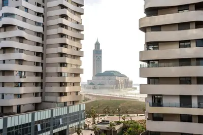 a view of the clock tower from between two buildings at شقة فاخرة - Luxury apartment in Casablanca
