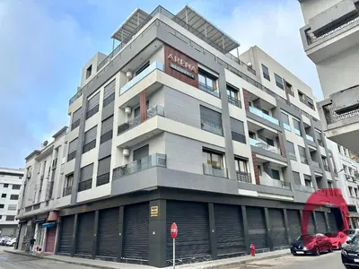a tall building on a city street with a stop sign at NESK STAY Maarif - ARENA 41 in Casablanca