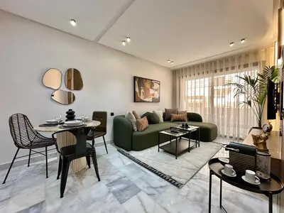 a living room with a green couch and a table at NESK STAY Maarif - ARENA 41 in Casablanca