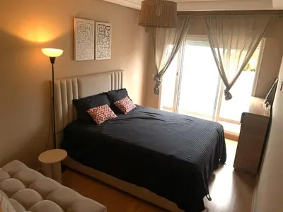 a bedroom with a bed and a large window at Chic & secure in Casablanca