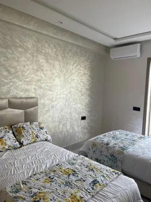 a bedroom with two beds and a wall mural at Appartement Luxueux Mer & Piscine in Mansouria