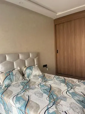 a bedroom with a large bed with a large bedspread at Appartement Luxueux Mer & Piscine in Mansouria