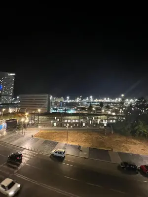 a city at night with cars parked in a parking lot at Confort Urbain Casablanca Vue Accès Gare Casa Port in Casablanca
