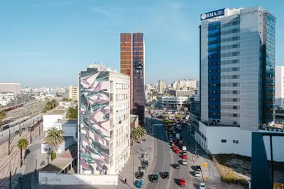 a city with buildings and cars on a street at Confort Urbain Casablanca Vue Accès Gare Casa Port in Casablanca