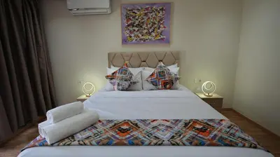 a bedroom with a large bed and two lamps at Panoramique Studio a casablanca in Casablanca