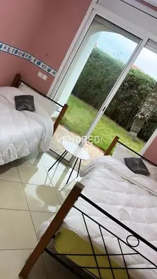 two beds in a room with a large window at Appartement à Garden Beach , Sidi Rahal in Sidi Rahal