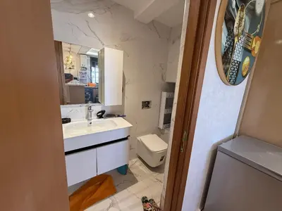 a bathroom with a sink and a toilet and a mirror at Comfortable apartment temara in Temara